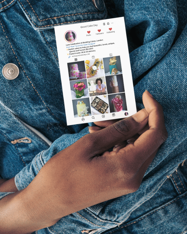 Hand holding a phone with an Instagram-style business card on a denim background