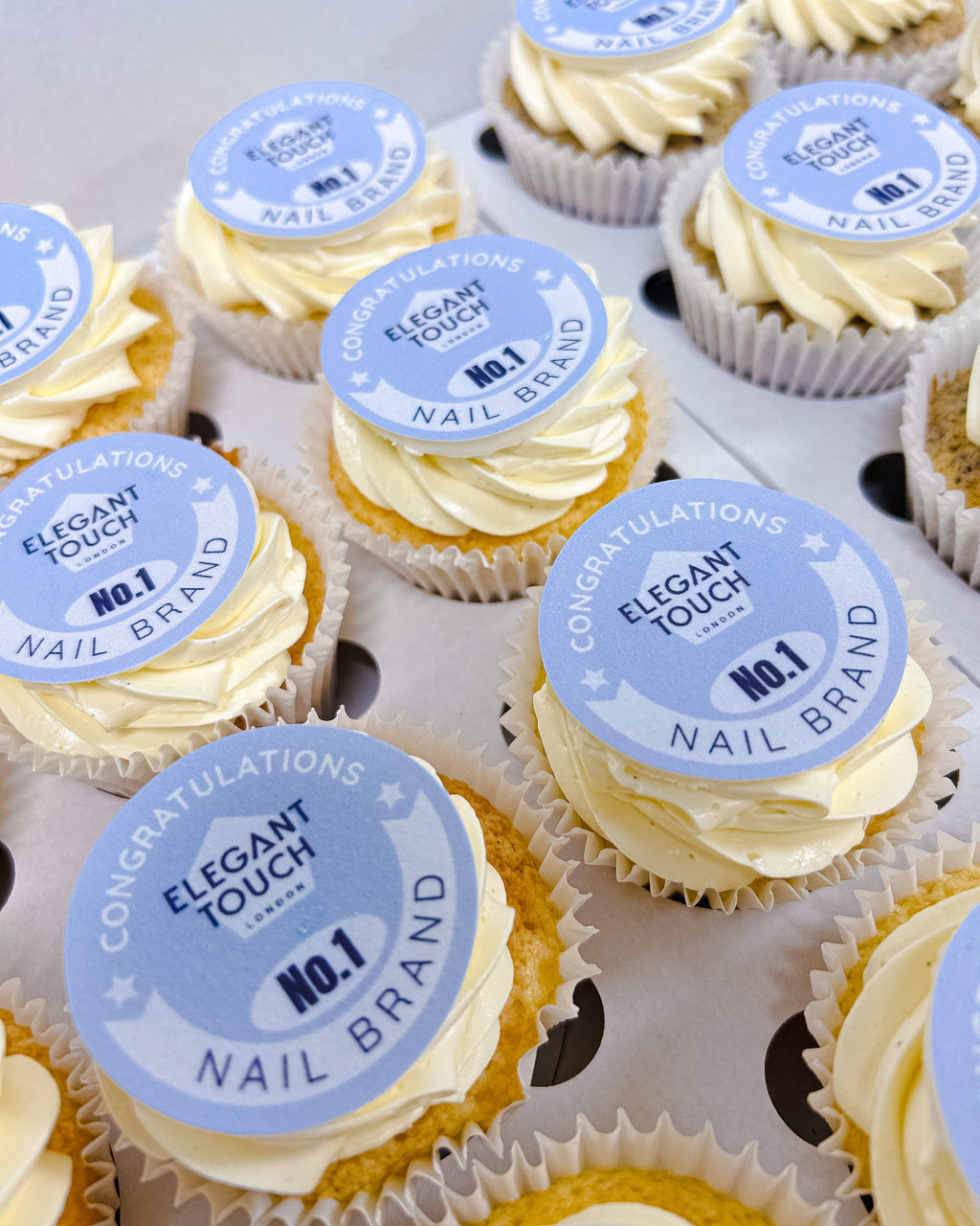 Cupcakes with 'Elegant Touch' branding on a white surface