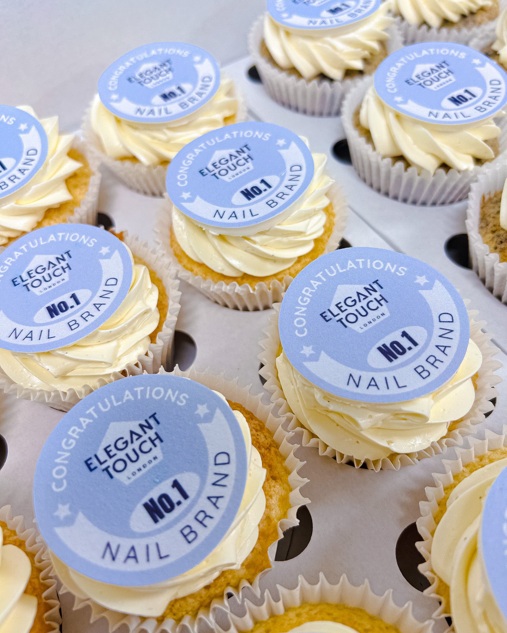 Cupcakes with 'Elegant Touch' branding on a white surface