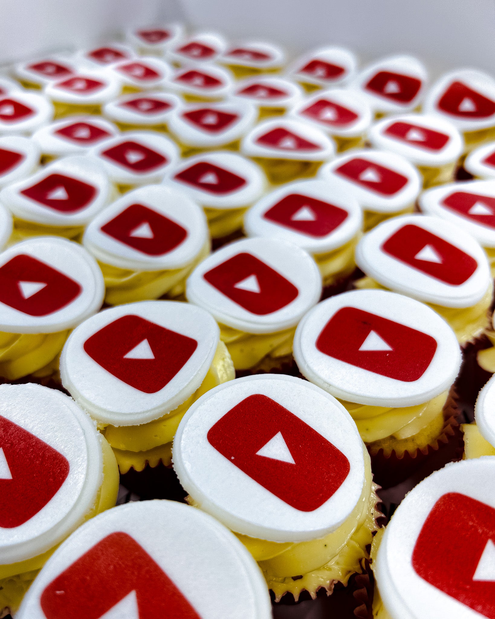 Mini Cupcakes with YouTube logo on top arranged in rows.