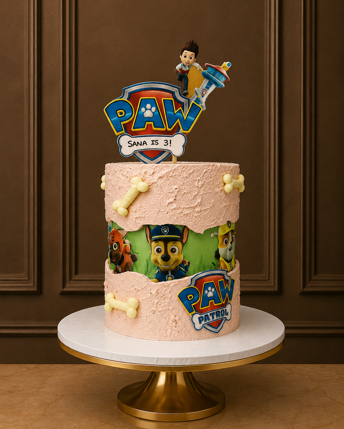 A custom Paw Patrol birthday cake with a pink frosting exterior, a torn-edge design showing cartoon characters, and a large 'PAW' topper on a white cake stand against a brown paneled wall.