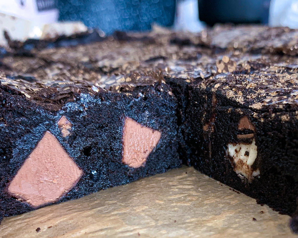 2 slices of dark chocolate brownies with white and milk chocolate chunks 