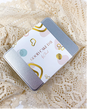 Load image into Gallery viewer, A silver rectangle food tin with a Good Cake Day sleeve across the middle of it. 
